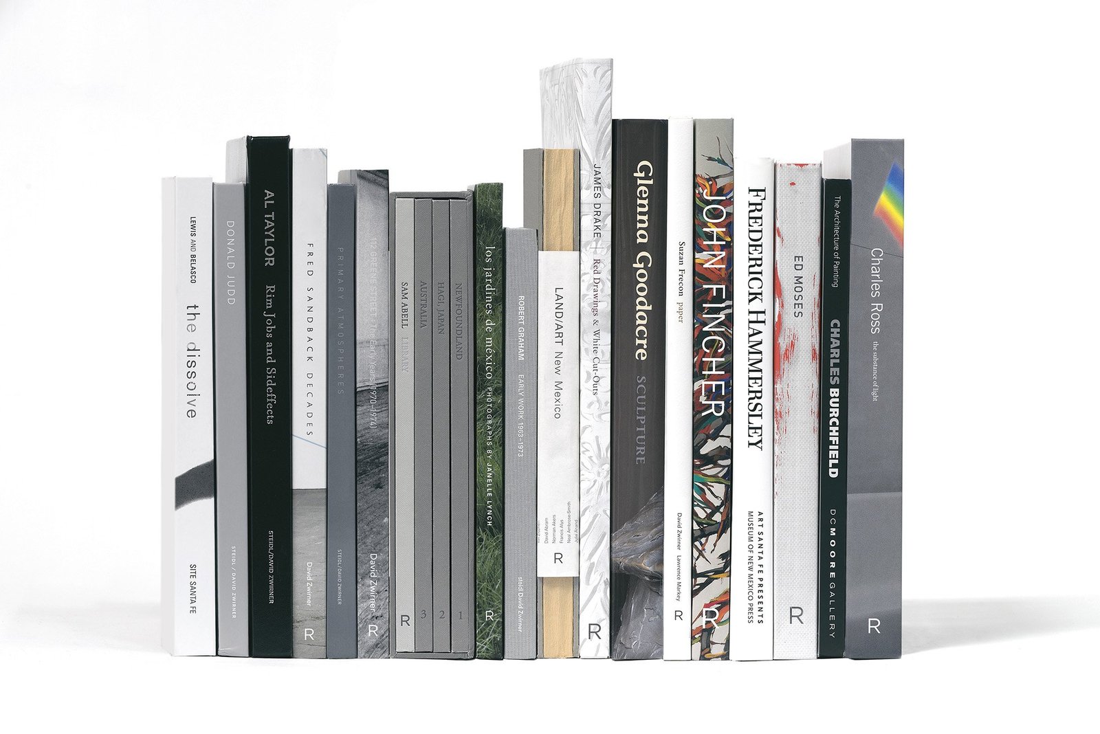 A row of art books and exhibition catalogues standing on end, spines out.